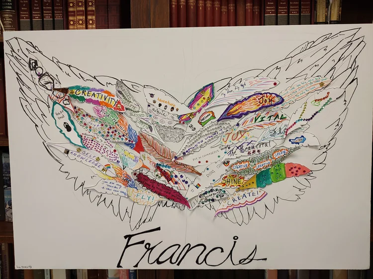 Francis' wings board made for a coming of age celebration, its paper feathers covered in handwritten wishes