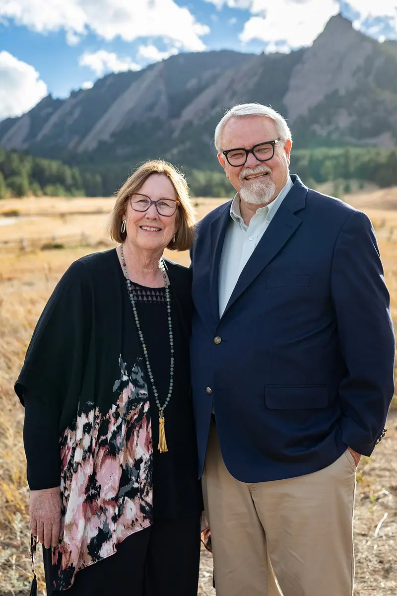 Benjamin and Teri Martin smiling together in a meadow below the Flatirons